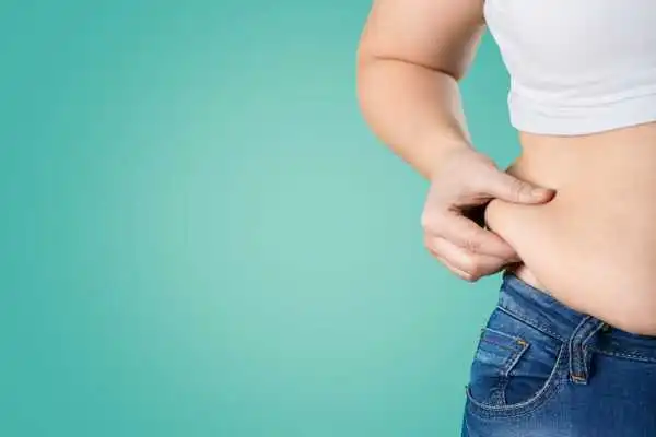 Image of woman pinching her love handles to show weight gain Livingston